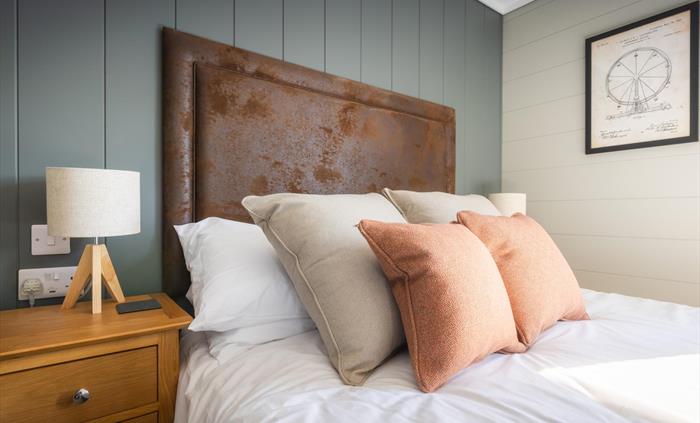 Double bed with vintage fairground artwork on the wall